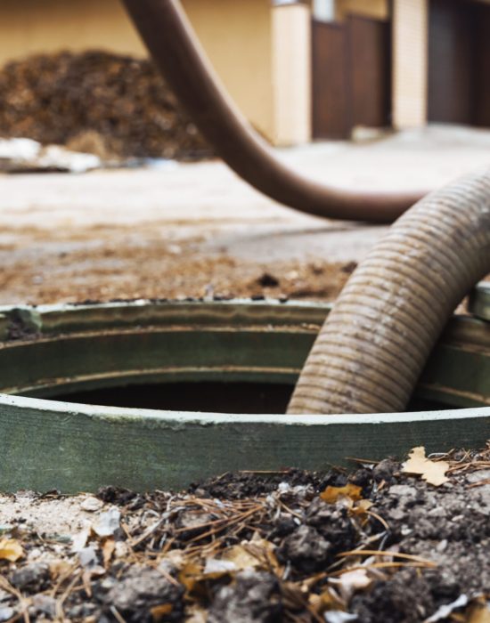 Pipe in the drainage pit. Pumping out sewage from a septic tank. Septic tank service